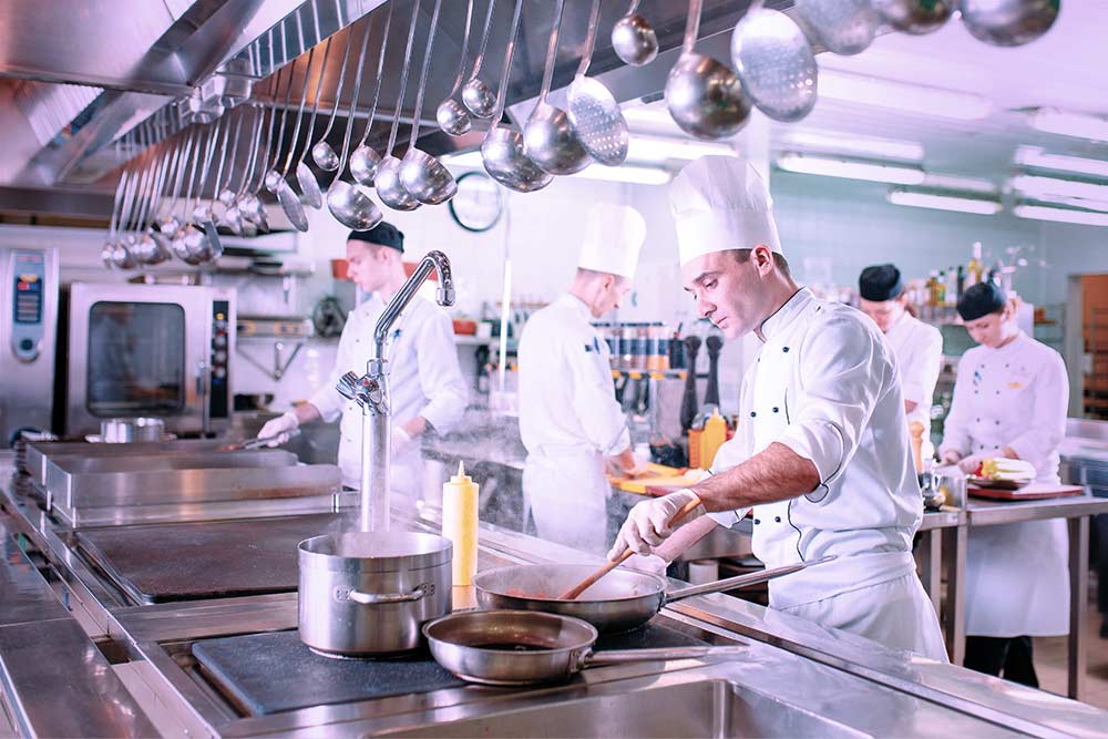 Large kitchen with stainless steel equipment.